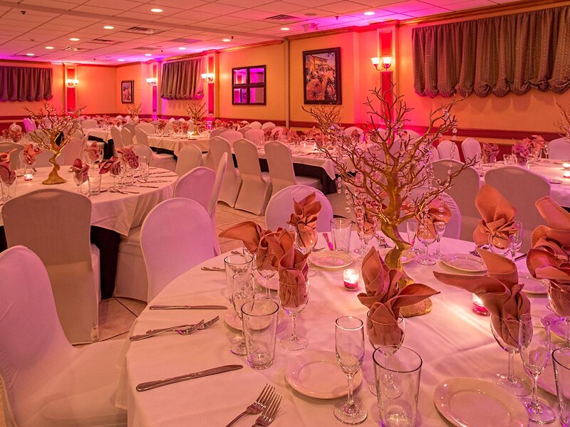 Duomo room with set tables with white table cloths, pink napkins and golden table center peices
