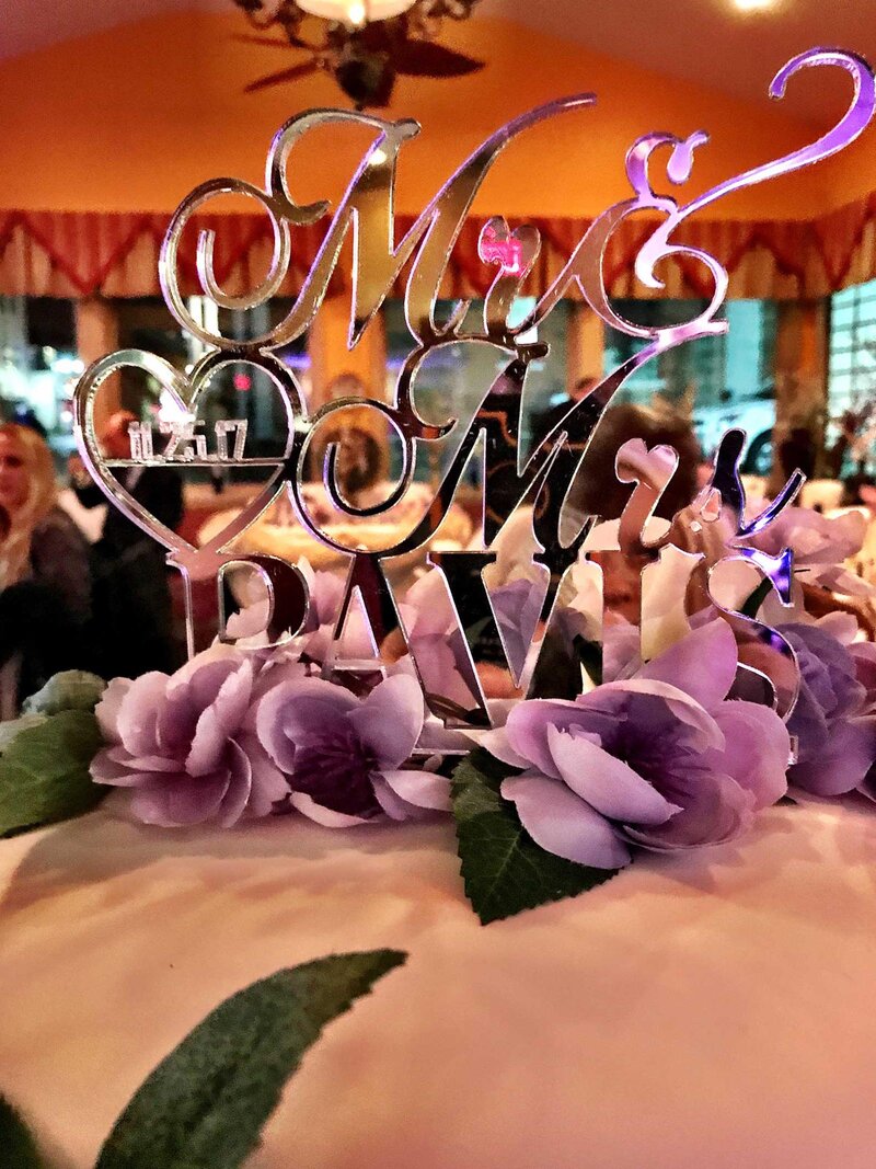 Wedding cake topped with decoration with the name of the newlyweds