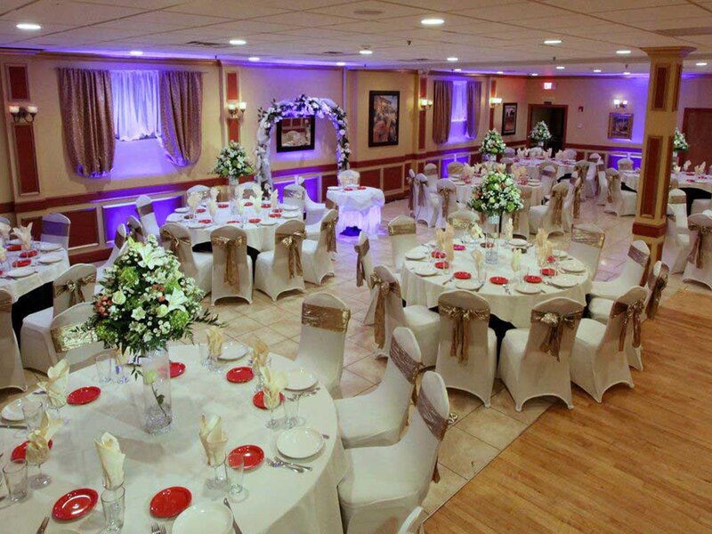 Duomo room with white linen, gold napkins and flower bouquet center pieces
