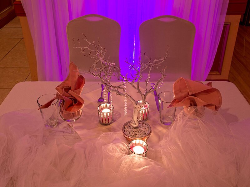 Duomo room with set table for two with pink napkins and white linen with candles and a center piece